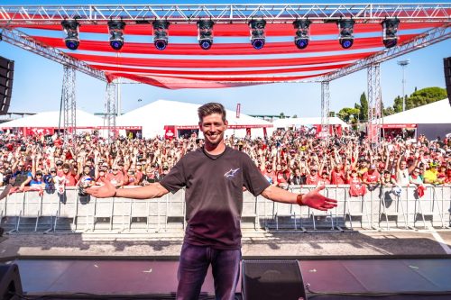 Performer mit ausgebreiteten Armen auf der Bühne vor großem Publikum bei der World Ducati Week 2026 in Misano
