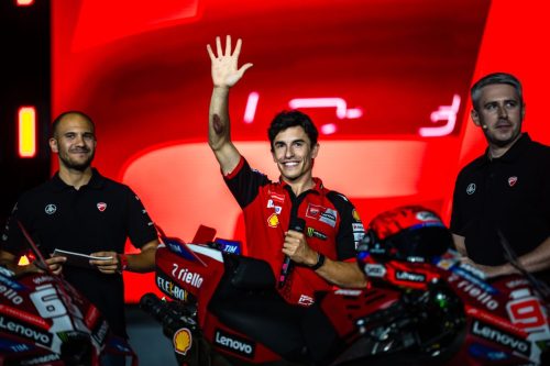 Ducati-Werksfahrer winkt auf der Bühne neben seiner roten Ducati Lenovo bei der Live the Legend Night in Misano