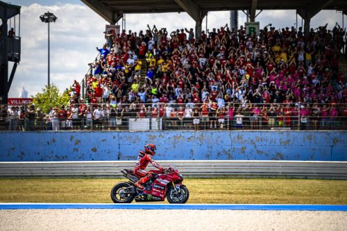 Fahrer auf roter Ducati auf der Strecke vor voll besetzten Tribünen bei der World Ducati Week 2026 in Misano