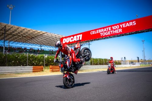 Fahrer im Wheelie unter dem Ducati-Torbogen Celebrate 100 Years Together auf der Strecke in Misano
