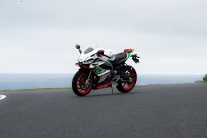 Aprilia RS 660 Phillip Island Tribute schräg von vorn links auf dem Asphalt des Phillip Island Circuit vor dem Meer