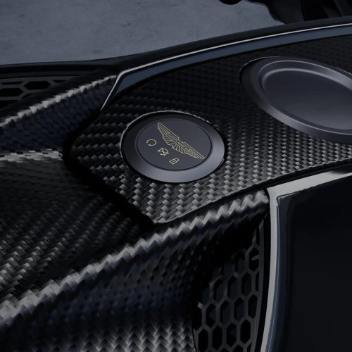 Aston Martin AMB 002 (2027) – Detailansicht des beleuchteten Zündknopfs mit Aston-Martin-Flügelemblem auf Carbonverkleidung