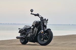 Benda Rock 707 2027 – Frontdreiviertelansicht am Strand vor diesigem Meer