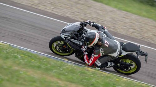 Benelli Tornado 550 2026 in Tech Silver beim Fahrtest auf dem Autodromo di Modena, Fahrerin mit Startnummer 17 in enger Schräglage, Knie nah an der Fahrbahn, grüne Wiese im Hintergrund