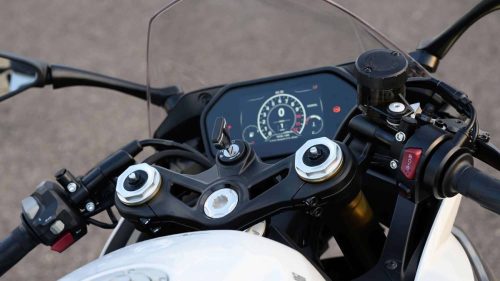 Cockpit-Detailaufnahme der Benelli Tornado 550 2026 in Gres White: TFT-Farbdisplay mit Drehzahlmesser und Fahrmodusanzeige 'Normal', Zündschloss, goldene Gabelbrücke und weißer Tank im Vordergrund