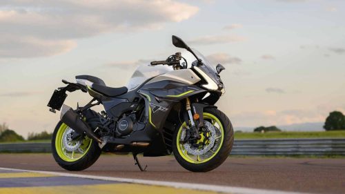 Benelli Tornado 550 2026 in Tech Silver auf der Rennstrecke Autodromo di Modena bei Sonnenuntergang, Seiten-Frontalansicht auf dem Seitenständer, warmes Abendlicht und Streckenbegrenzung im Hintergrund