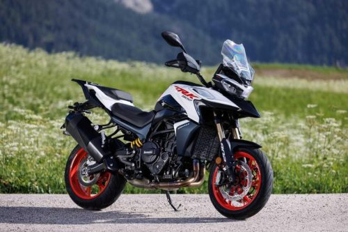 Benelli TRK 902 Stradale (2026) – Seitenansicht in Weiss/Rot mit rot eloxierten Gussraedern auf einer Almwiese in den Dolomiten