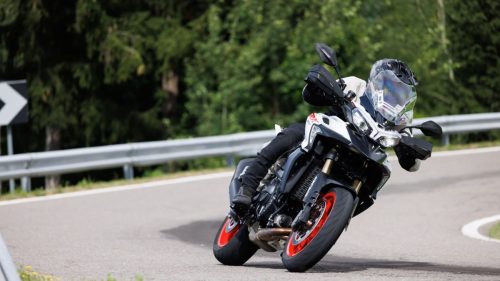 Benelli TRK 902 Stradale (2026) – Fahraufnahme in Schraeglage auf Landstrasse in den Dolomiten, Fahrer in Vollmontur