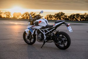 BMW F 450 R 2027 – M Sport in Snaefell Weiß / M Motorsport, Standaufnahme schräg von hinten links bei Sonnenuntergang mit weißem Gitterrohrrahmen