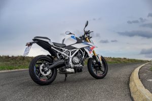 BMW F 450 R 2027 – M Sport in Snaefell Weiß / M Motorsport, Standaufnahme schräg von hinten rechts mit Reihenzweizylinder und Underfloor-Auspuff