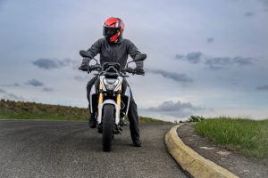 BMW F 450 R 2027 – M Sport in Snaefell Weiß / M Motorsport, Frontansicht mit aufsitzendem Fahrer mit rotem Helm im Stand