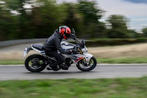 BMW F 450 R 2027 – M Sport in Snaefell Weiß / M Motorsport, Fahraufnahme schräg von hinten links mit weißem Rahmen