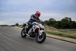 BMW F 450 R 2027 – M Sport in Snaefell Weiß / M Motorsport, Fahraufnahme frontal in einer langgezogenen Kurve