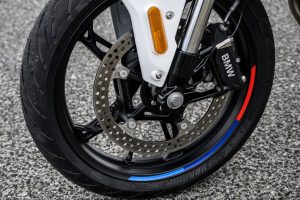 BMW F 450 R 2027 – Detailansicht des Vorderrads mit 310-mm-Bremsscheibe und Felgenrandaufkleber in M-Farben