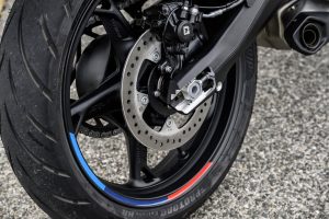 BMW F 450 R 2027 – Detailansicht des Hinterrads mit 17-Zoll-Gussfelge, Felgenrandaufkleber in M-Farben und Bremsscheibe