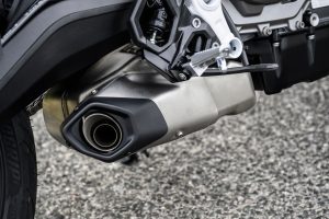 BMW F 450 R 2027 – Detailansicht des Edelstahl-Schalldämpfers unter dem Motor und der geschmiedeten Fußraste