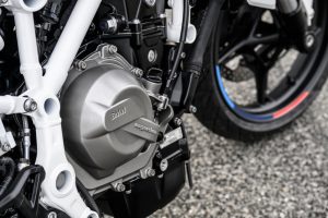 BMW F 450 R 2027 – Detailansicht des Reihenzweizylinders mit Magnesium-Kupplungsdeckel im weißen Stahlrahmen