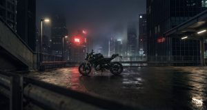 BMW F 450 R 2027 – in Cosmic Black auf einem nassen Parkdeck vor nebliger Skyline bei Nacht (KI-generiertes BMW-Pressebild)