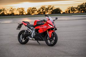 BMW F 450 RR 2027 – Sport in Racing Red, Standaufnahme schräg von vorn mit Blick auf Verkleidung, Winglets und goldene Gabel im Gegenlicht