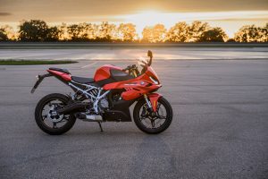BMW F 450 RR 2027 – Sport in Racing Red, Seitenansicht auf Asphalt mit weißem Gitterrohrrahmen und Unterflurschalldämpfer