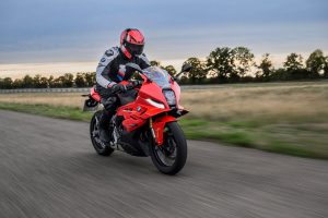 BMW F 450 RR 2027 – Sport in Racing Red in Fahrt auf der Rennstrecke, Fahrer frontal auf die Kamera zufahrend