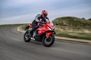 BMW F 450 RR 2027 – Sport in Racing Red in Fahrt durch eine Kurve der Rennstrecke, Ansicht schräg von vorn