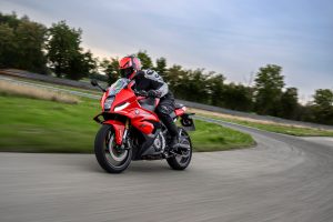 BMW F 450 RR 2027 – Sport in Racing Red in Fahrt am Kurvenausgang, Fahrer mit rot-schwarzem Helm