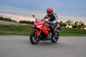 BMW F 450 RR 2027 – Sport in Racing Red in Fahrt auf der Rennstrecke unter bewölktem Abendhimmel