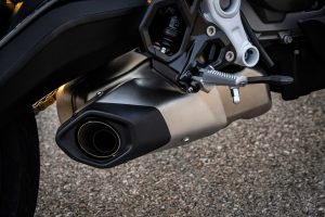 BMW F 450 RR 2027 – Sport in Racing Red, Detailaufnahme des Unterflurschalldämpfers aus Edelstahl und der Fußraste