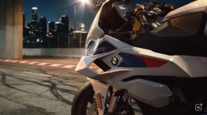 BMW F 450 RR 2027 – M Sport in Snaefell Weiß / M Motorsport, Nahaufnahme der Verkleidung mit BMW-Logo vor nächtlicher Skyline (KI-generiertes BMW-Pressebild)