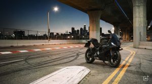 BMW F 450 RR 2027 – Basis in Cosmic Black auf einer Straße mit gelber Mittellinie unter einer Hochstraße bei Nacht (KI-generiertes BMW-Pressebild)