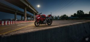 BMW F 450 RR 2027 – Sport in Racing Red auf einer Straße an rot-weißen Absperrungen in der Abenddämmerung (KI-generiertes BMW-Pressebild)