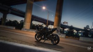 BMW F 450 RR 2027 – Basis in Cosmic Black auf einer Straße unter Hochstraßen in der Abenddämmerung (KI-generiertes BMW-Pressebild)