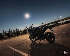 BMW F 450 RR 2027 – Basis in Cosmic Black auf Asphalt mit Skyline und Straßenlaterne im Hintergrund (KI-generiertes BMW-Pressebild)