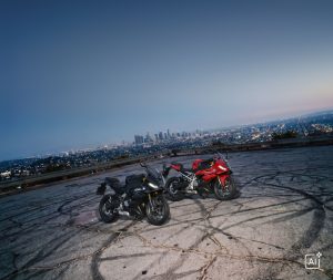 BMW F 450 RR 2027 – F 450 RR in Schwarz und Rot auf einem Aussichtsplatz über der Stadt in der Dämmerung (KI-generiertes BMW-Pressebild)