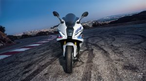 BMW F 450 RR 2027 – M Sport in Snaefell Weiß / M Motorsport, Frontansicht auf Asphalt mit Reifenspuren an einer Bergstraße (KI-generiertes BMW-Pressebild)