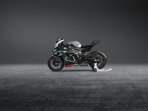 BMW M 1000 RR Limited Edition Isle of Man TT 2026 – Linke Seitenansicht in British Racing Green Uni Matt mit Mountain-Course-Grafiken, Aluminium-Tank in Satin Chrom und schwarzer Alcantara-Sitzbank, grauer Studiohintergrund