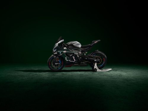 BMW M 1000 RR Limited Edition Isle of Man TT 2026 – Rechte Seitenansicht in British Racing Green Uni Matt mit Rechtskurven-Grafiken des TT Mountain Course, Aluminium-Tank in Satin Chrom und schwarzer Schwinge, dunkles Studio mit grünem Spotlight