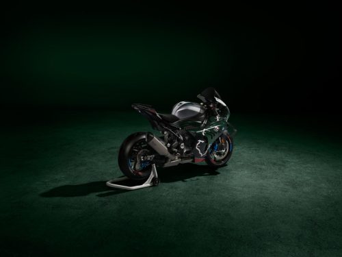 BMW M 1000 RR Limited Edition Isle of Man TT 2026 – Heckansicht schräg rechts in British Racing Green Uni Matt mit Aluminium-Tank in Satin Chrom, schwarzer Schwinge und TT-Grafiken, dunkles Studio mit grünem Spotlight
