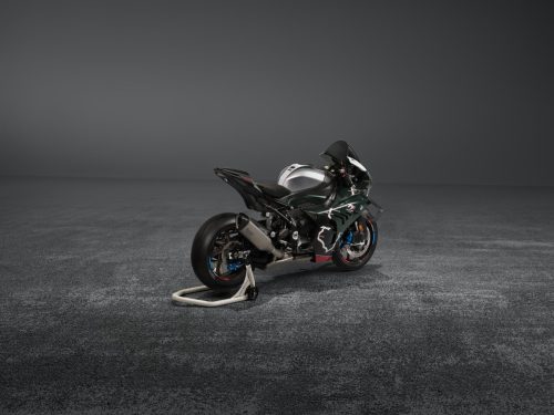 BMW M 1000 RR Limited Edition Isle of Man TT 2026 – Heckansicht schräg rechts in British Racing Green Uni Matt mit Aluminium-Tank in Satin Chrom und M Montageständer, grauer Studiohintergrund