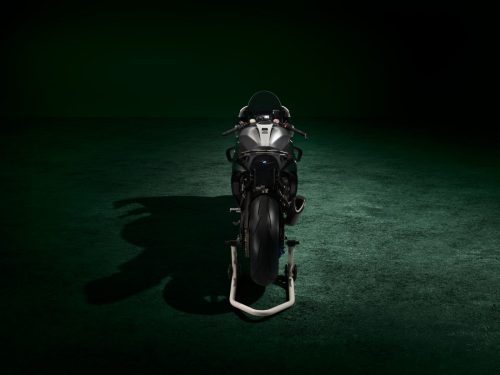 BMW M 1000 RR Limited Edition Isle of Man TT 2026 – Heckansicht von hinten mit Aluminium-Tank in Satin Chrom und M Montageständer, dunkles Studio mit grünem Spotlight
