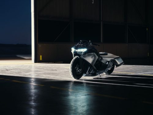BMW Motorrad Vision K18 – Frontansicht im Flugzeughangar bei Nacht mit leuchtenden LED-Scheinwerfern