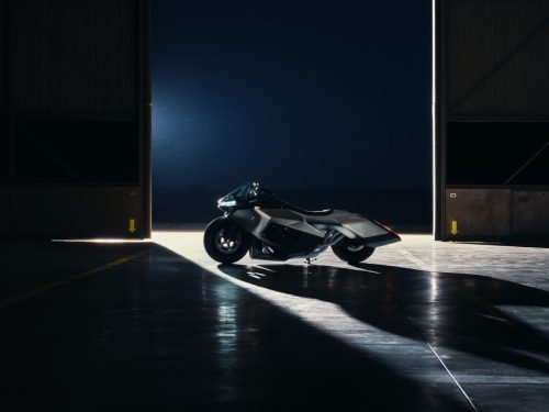 BMW Motorrad Vision K18 – Seitenansicht im Hangar-Tor mit dramatischer Gegenlichtbeleuchtung auf Rollfeld
