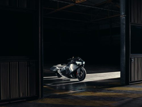 BMW Motorrad Vision K18 – Heckperspektive im Hangar mit sichtbarem Sechszylinder-Auspuffkrümmer und Aluminium-Karosserie