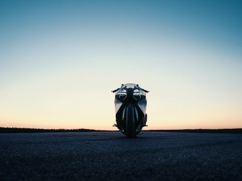 BMW Motorrad Vision K18 – Frontansicht auf Startbahn bei Sonnenuntergang mit leuchtender LED-Signatur