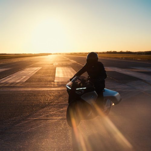 BMW Motorrad Vision K18 – Fahrer fährt auf Startbahn Richtung Sonne mit Lens-Flare und Heat-Haze-Effekt