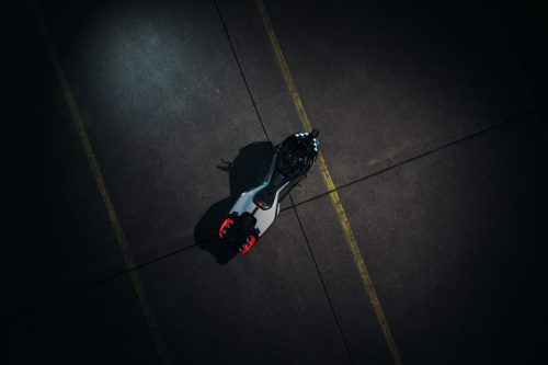BMW Motorrad Vision K18 – Vogelperspektive auf Rollfeld mit rotem Rücklicht und pfeilförmiger Silhouette