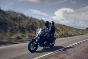 BMW R 12 2025 – Frontansicht mit Soziusfahrt auf Landstraße, Aventurinrot