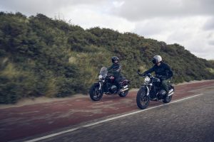 BMW R 12 2025 – beide Modelle nebeneinander in Fahrt, Aventurinrot und Schwarz