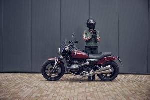 BMW R 12 2025 – Seitenansicht mit stehender Fahrerin, Aventurinrot